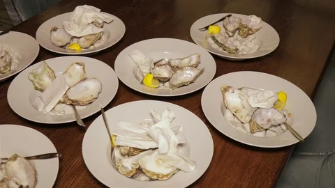 Dirty plates with empty oyster shells on a wooden table in the restaurant. Stock Footage 96357376