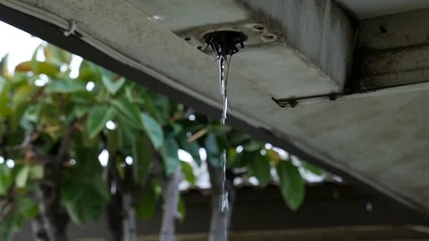 Dirty rain gutter with water falling out in slow motion. Stock Footage 121496249