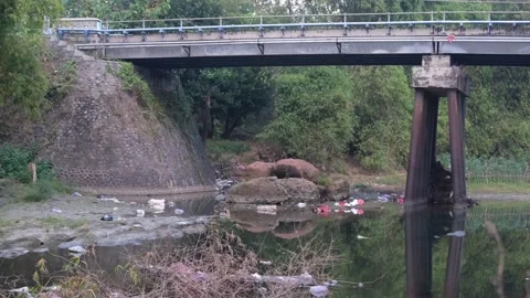 Dirty river with plastic trash and domestic waste under the bridge Stock Footage 158463802