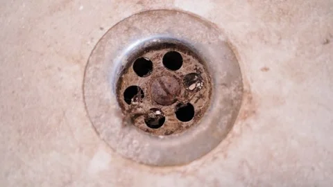 Dirty rusty bathroom drain close-up. Hair and dirt in the sink. Camera rotation Stock Footage 231688676