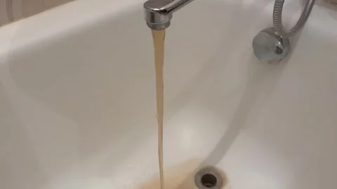 Dirty, rusty water flows out of a modern faucet, making the sink dirty.	 Stock-Footage 317374695
