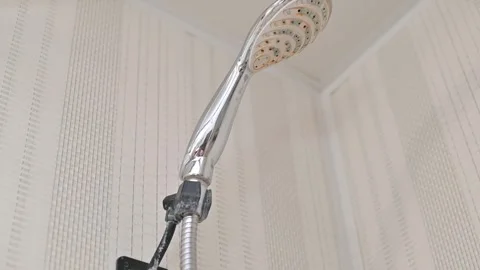 Dirty shower head and black fittings on the wall covered in limescale sediment Vidéo 337101416