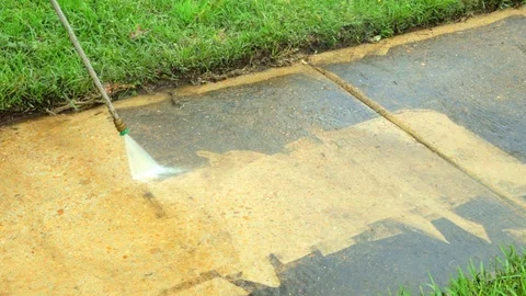 Dirty sidewalk being cleaned with water from a pressure washer. Stock Footage 127263406