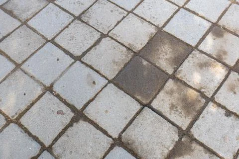 A dirty sidewalk with a few missing tiles Stock Photos