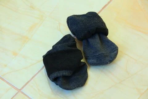 Dirty socks on tiled floor. Stock Photos