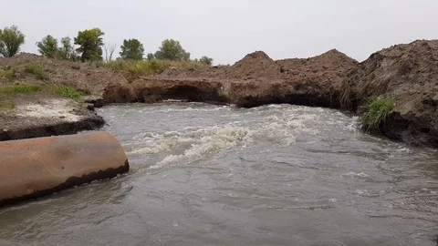 A dirty stream of water flows into the river Vídeo Stock 97642192