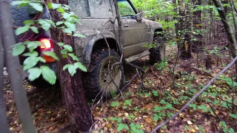Dirty SUV car driving through muddy trail in the woods Stock Footage 78626150