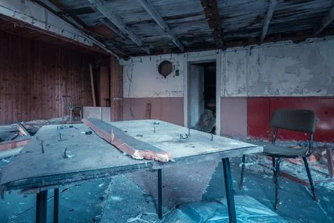 Dirty table with old nails in it and a chair in messy room of an old abandoned Stock Photos