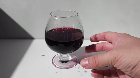 Dirty traces of red wine on the table. Hand takes a glass of wine Stock Footage 128243469