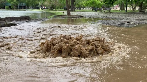 Dirty water bubbling out of a storm drain after heavy rain Video stock 254733448