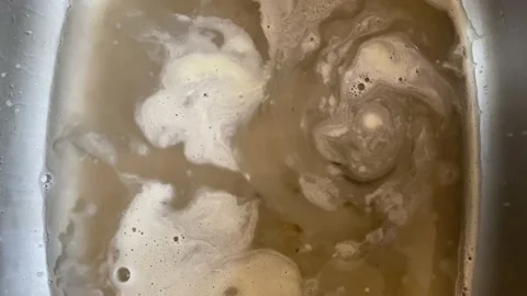 Dirty water draining down the kitchen sink after dishwashing Stock Footage 150740172