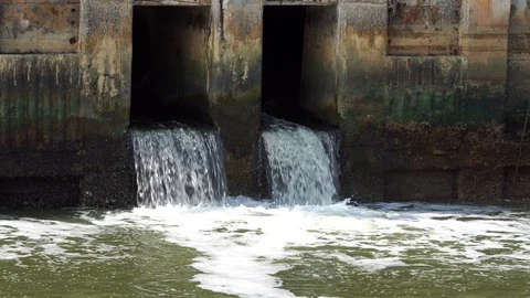 Dirty water flow to sewer from city,waste water flows from a pipe Stock Footage
