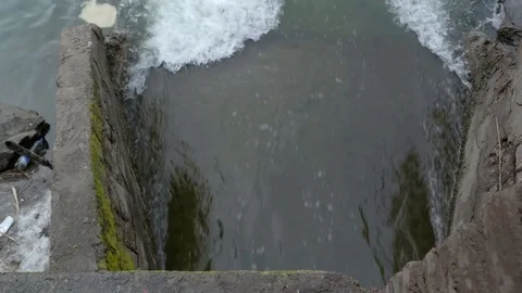 Dirty water flows from a pipe into the river. Water pollution and contamination Stock Footage 80759553