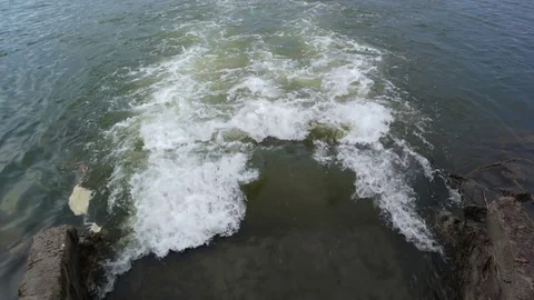 Dirty water flows from a pipe into the river. Water pollution and contamination Stock Footage 80759592