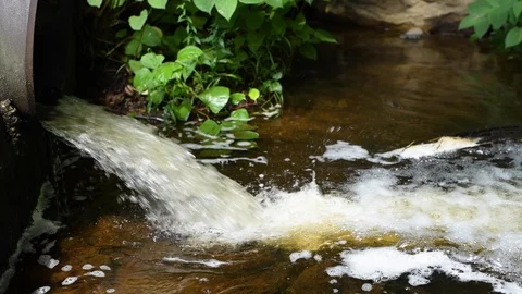 Dirty water flows from a pipe in river, environmental pollution. Stock Footage 112852190
