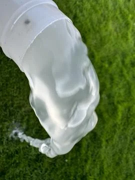 Dirty Water from Poolfilter Flowing from Pipe onto Grass Stock Photos