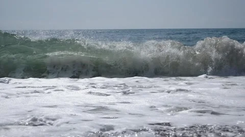 Dirty waves rise and break on the rocky shore forming foam. Stock Footage 334120747