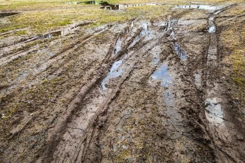 Dirty wet rural road with puddles and mud Stock Photos