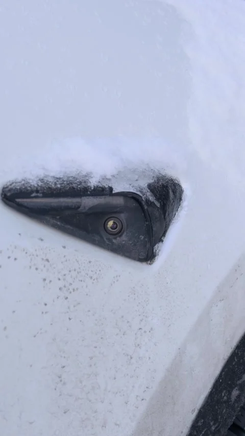 Dirty white electric car side camera blocked by snow and ice in winter Stock Footage 330295944