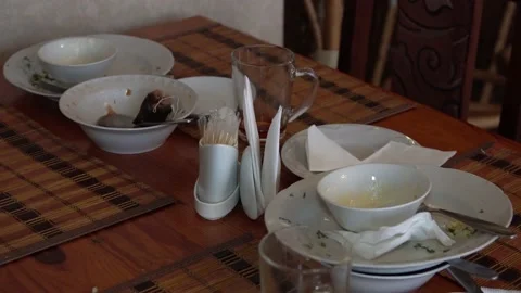 Dirty white plates stand on a table in a restaurant. close-up. Video stock 131761702