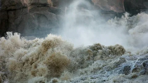 Dirty whitewater explodes through river gorge throwing up mist plumes Stock Footage 301169837
