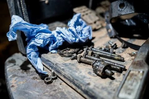 Dirty workshop surface with scattered bolts and tools Stock Photos