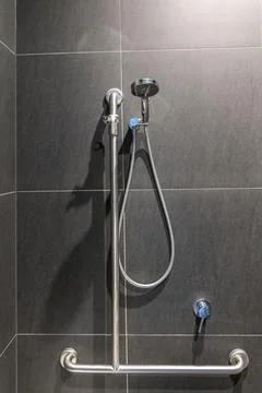 Disability friendly generic restroom with hand rails next to shower facility Stock Photos