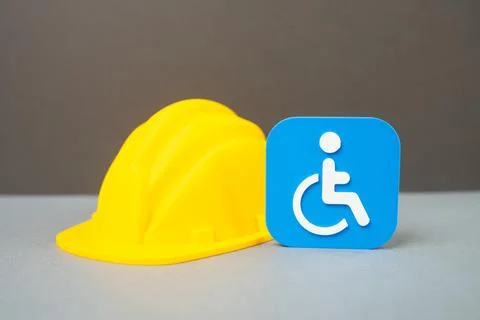 A disability symbol and a construction worker's hard hat. Concept of career.. Stock Photos
