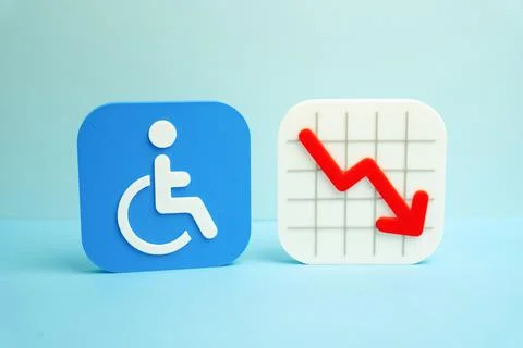 A disability symbol and a falling chart. Reduction of a population category.  Stock Photos