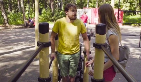 Disable man holding the parallel bars standing on his legs Stock-Fotos