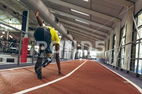 Disabled African American male athletic running on race track in fitness center Stock Photos