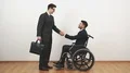 The disabled and a businessman handshake on the white wall background 4k or 4k+ Resolution