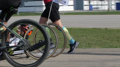 Disabled Athlete training with her Hand bike with Cyclist and Runners Stock Footage 144110549