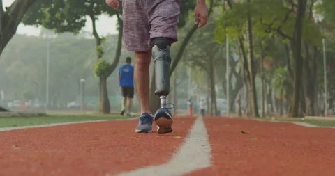 Disabled Athlete walking forward with prosthetic leg at running track Stock Footage 201135294