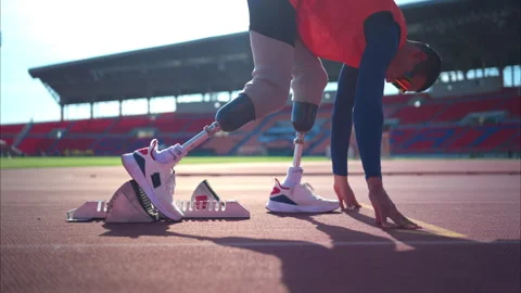 Disabled athletes prepare in starting position ready to run on stadium track Stock Footage 257661577