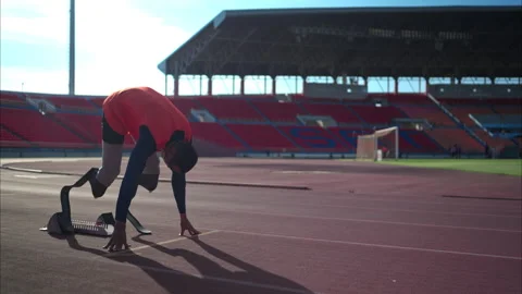 Disabled athletes prepare in starting position ready to run on stadium track Video stock 257666502