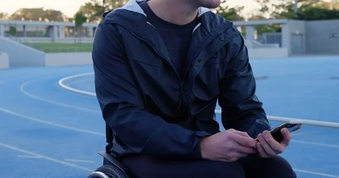 Disabled athletic using mobile phone at sports venue 4k Stock Footage 96094434