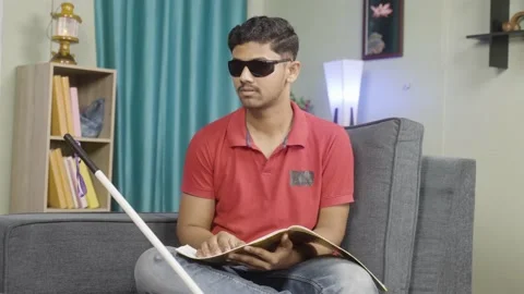 Disabled blind young man reading by touching book at home - concept of education Stock Footage 168130071