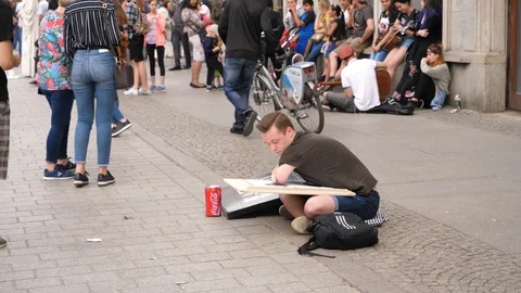 Disabled crippled handicapped young man artist busker on a street draw pictures Stock Footage 89487437