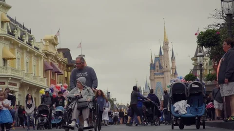 Disabled Elderly Disney Fans at Magic Kingdom Theme Park in Slow Motion Stock Footage 123932870