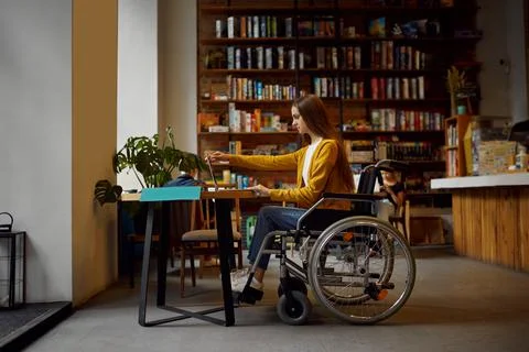 Disabled female student in wheelchair using laptop Stock Photos
