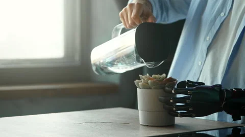 Disabled guy with hand prothesis pours water into pot plant Stock Footage 157535720