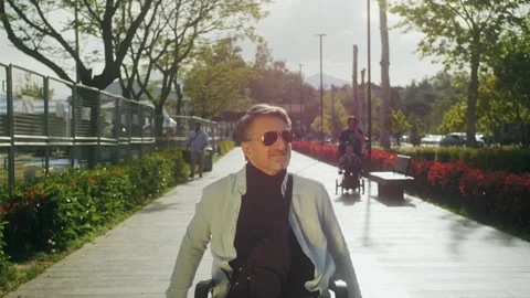 Disabled happy middle aged man user wheelchair. Arab handsome man walking in Stock Footage 258332266