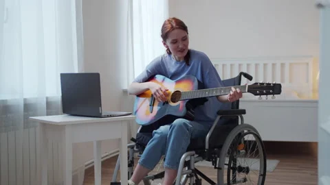 A disabled lady is playing the guitar and singing songs Stock Footage 163476644