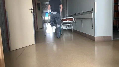 Disabled man with a broken leg uses crutches to walk. Stock Footage 306079223