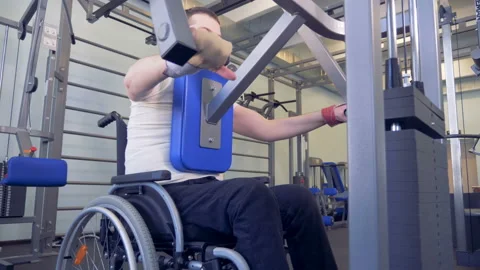 Disabled man does strengths exercises for back on training apparatus. Video stock 88091429