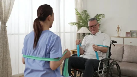 Disabled man doing resistance training with help Stock Footage 204789175