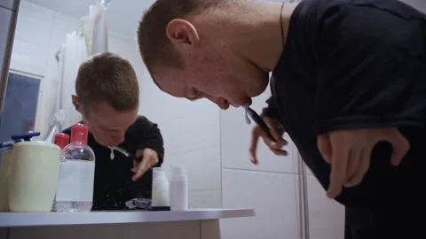 Disabled man with dwarfism brushing his teeth in bathroom mirror Vidéo 321942405