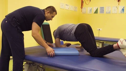Disabled man lays down on a massage table at the rehabilitation center. Stock Footage 93826360