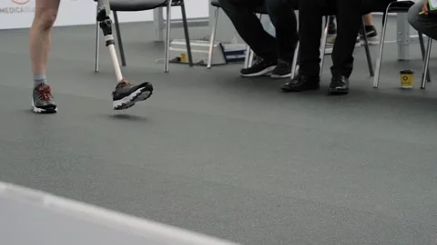 Disabled man with leg prosthesis walking in front of the jury at competition Stock Footage 149926206